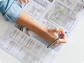 Persona analizando planos técnicos y esquemas de un proyecto de puertas automáticas.